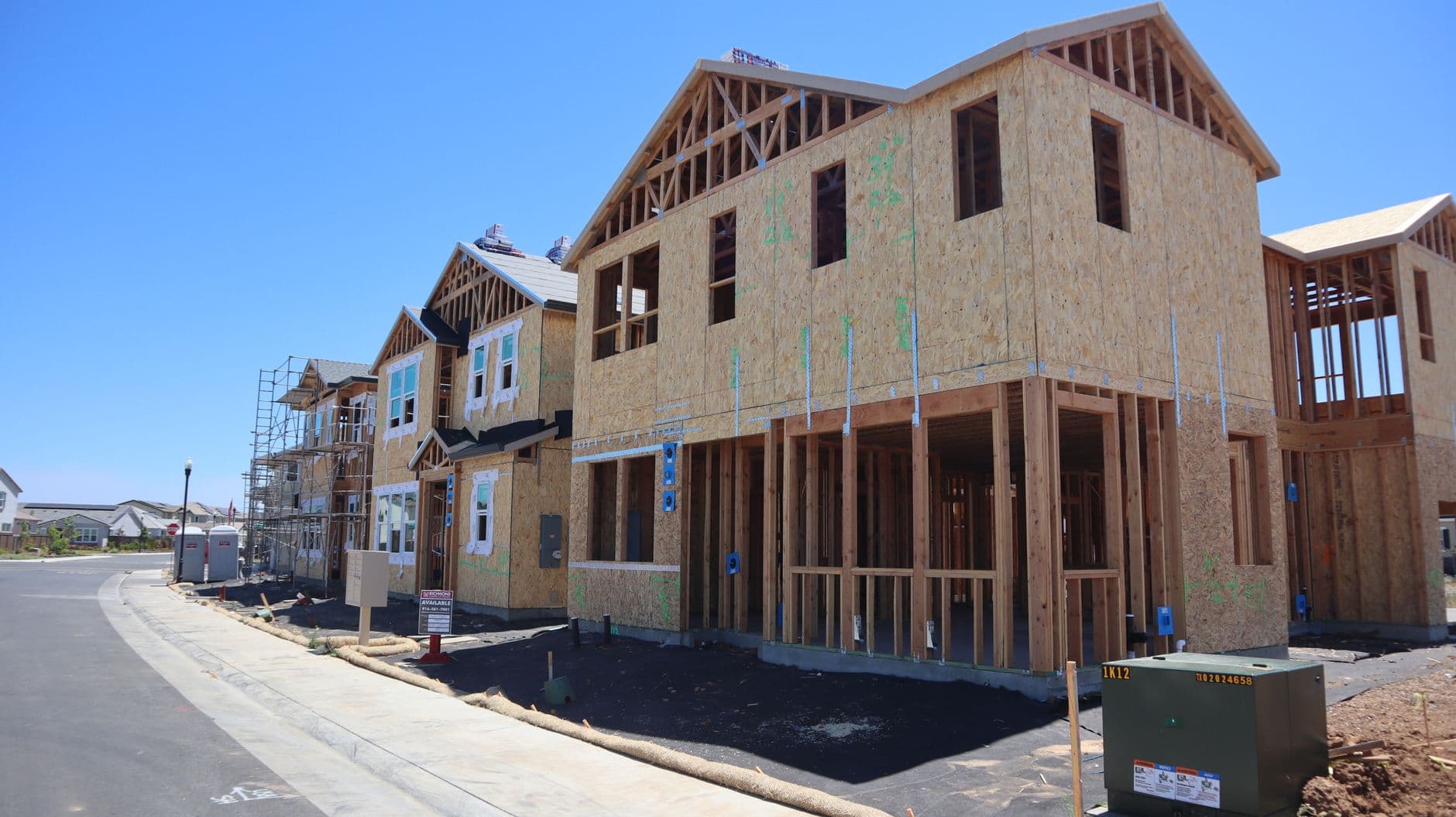 Row of new homes under construction, timber frames and sheathing in place