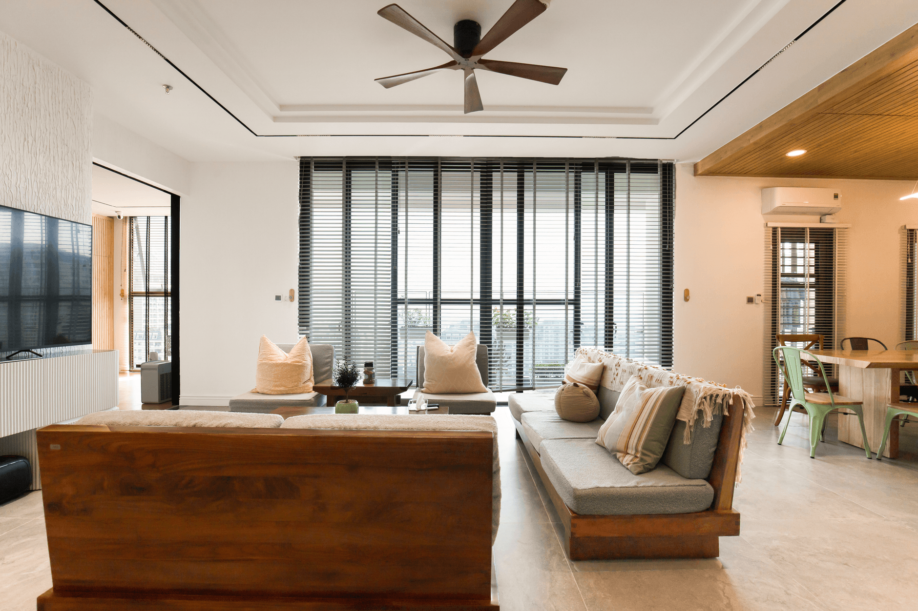 Open-plan living room with a timber feature wall and full-height glazing to the garden