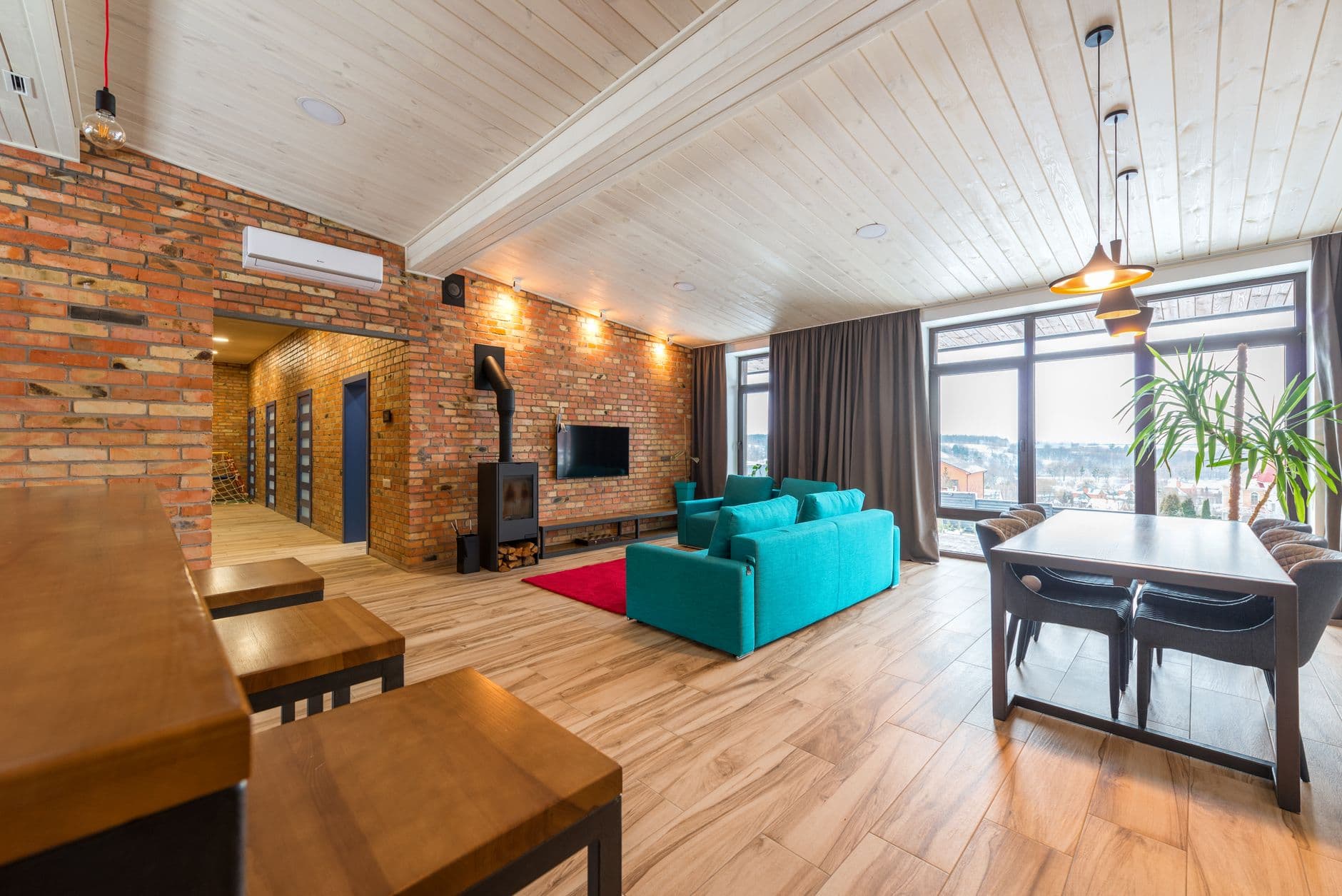 Living space with exposed brick, a panelled ceiling and full-width glazing