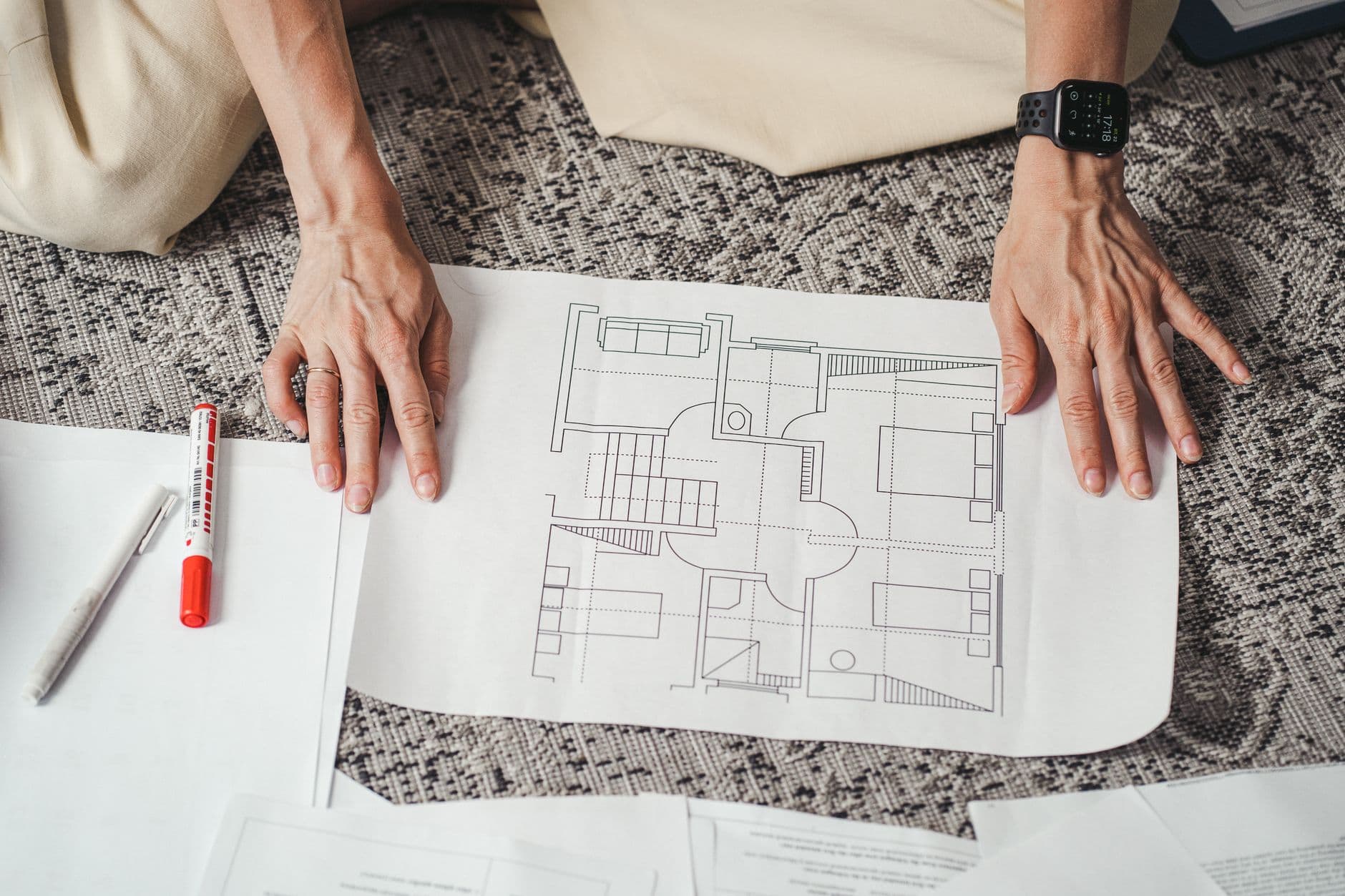 Hands spread across a detailed architectural floor plan
