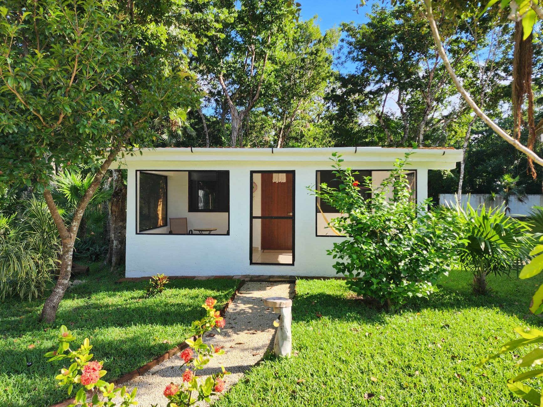 Small detached garden building surrounded by mature planting