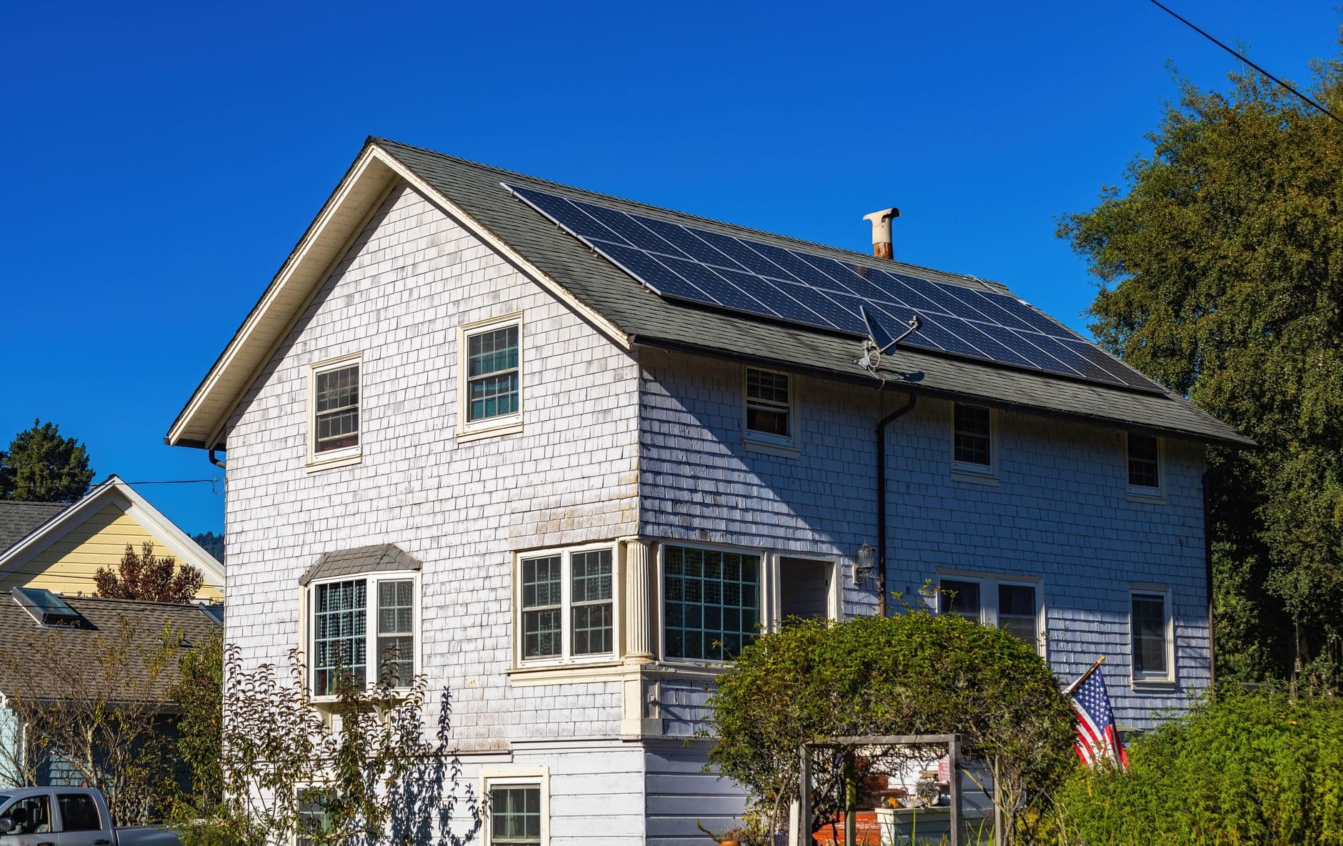 Two-storey home with rooftop solar panels against a clear sky