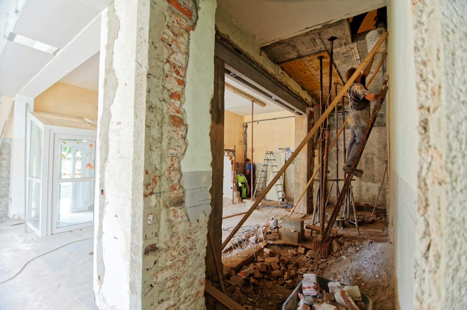Interior of a home mid-construction, a temporary post carrying a newly opened structural wall